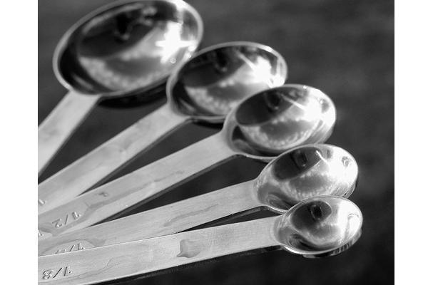 A set of stainless steel measuring cups and spoons with precise markings and a variety of sizes