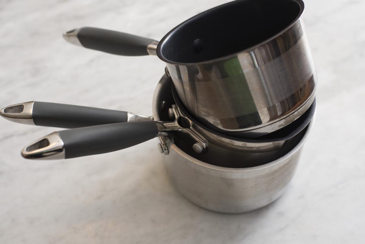 A set of high-quality stainless steel saucepans with copper or aluminum cores for even heat distribution